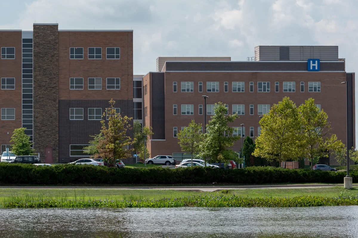 Hospital exterior with clinical buildings and a clearly visible hospital H sign