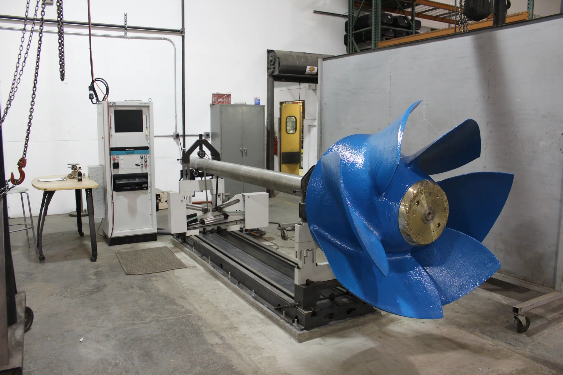 Blue industrial impeller mounted in balancing equipment